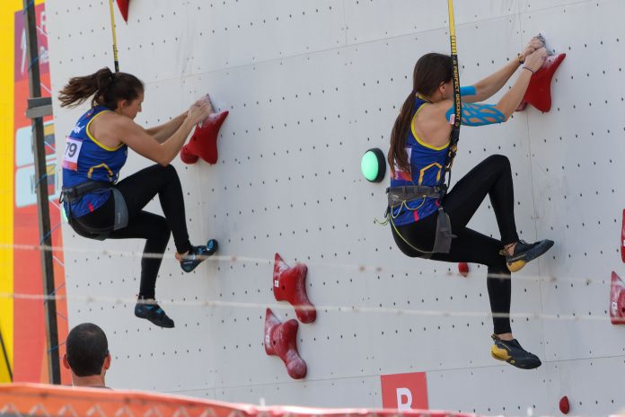 Dos atletas compitiendo en una prueba de escalada en muro vertical